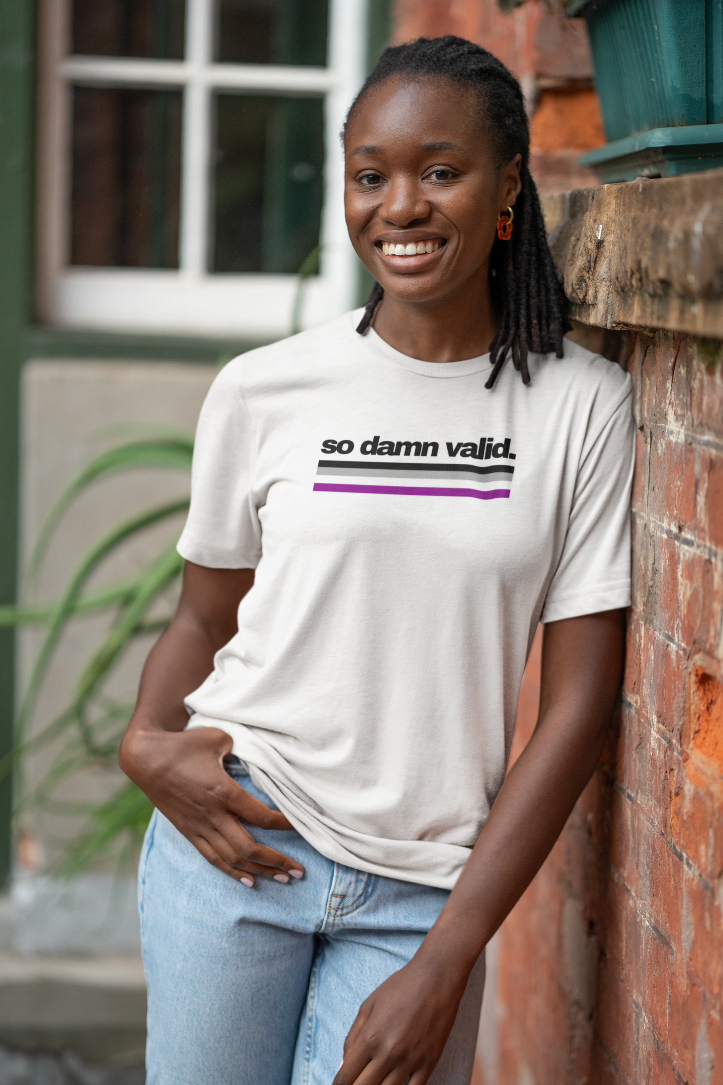 Unisex white t-shirt with the phrase "so damn valid." in black text above horizontal asexual pride stripes in black, gray, white, and purple.
