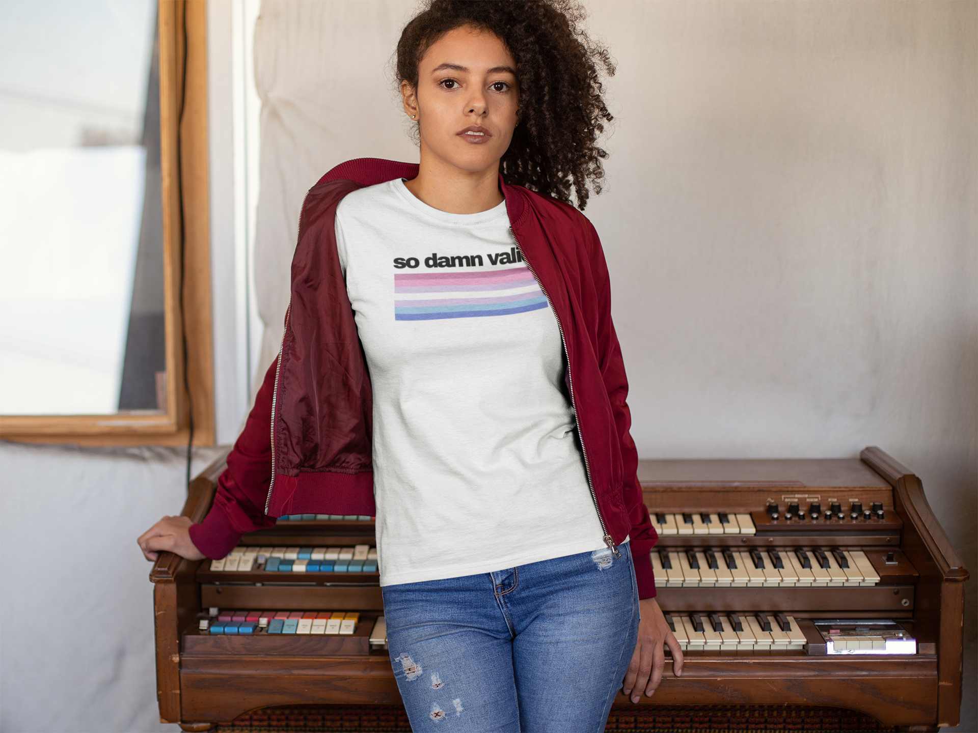 Unisex white t-shirt with the phrase "so damn valid." in black text above horizontal bigender pride stripes in pink, lavender, white, light blue, and royal blue.
