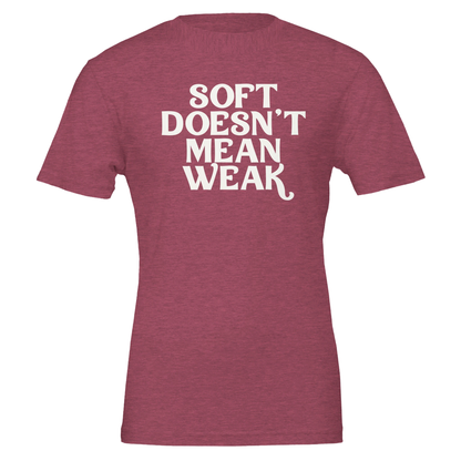 Flat lay of heather raspberry t-shirt with bold white text that reads “Soft Doesn’t Mean Weak.”