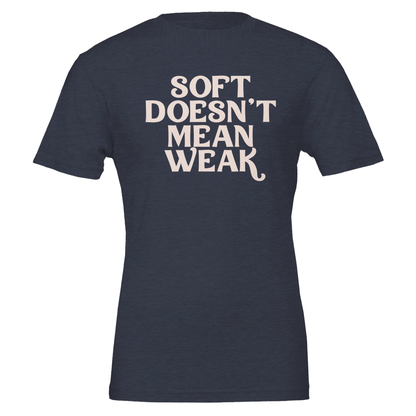 Flat lay of navy t-shirt with the phrase “Soft Doesn’t Mean Weak” printed in cream white text.
