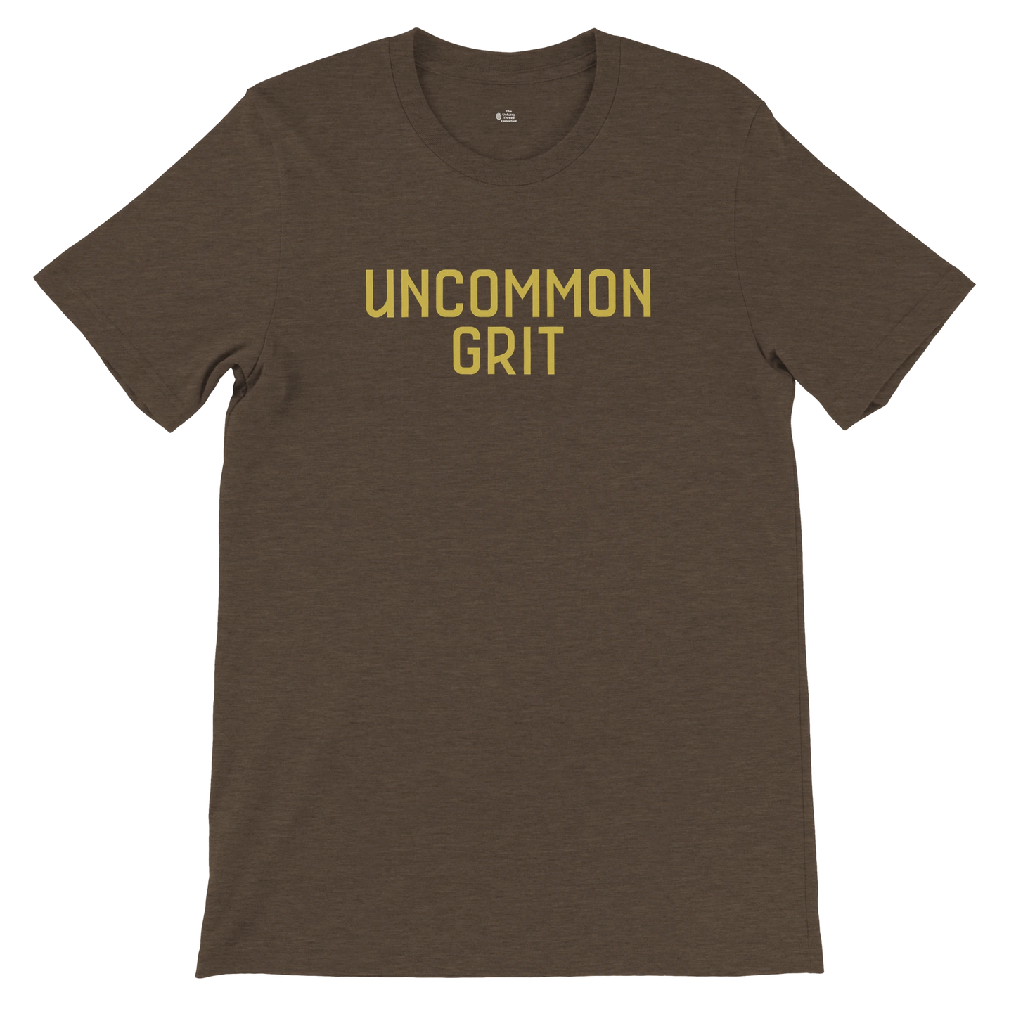 Flat lay of the Uncommon Grit Legacy Edition tee in Heather Brown with bold gold text on the chest.